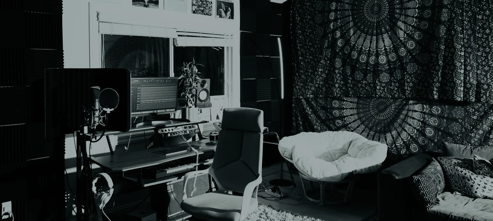 The live room: foam-treated walls, the desk and monitors, chairs and a tapestry.