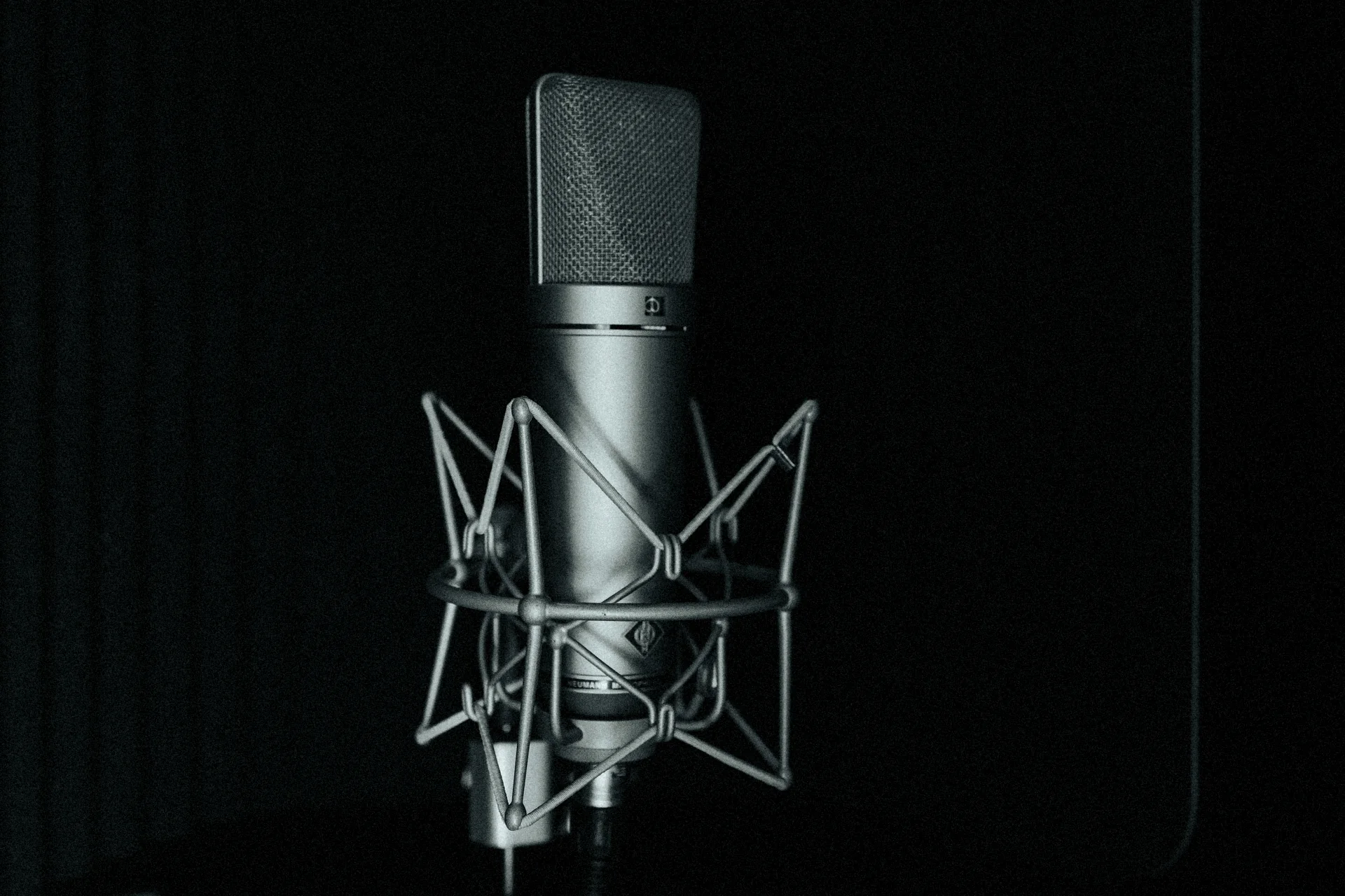 The studio's Neumann U 87 Ai in its shockmount, alone in a dark room.